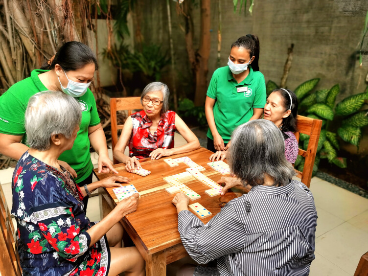 Seniors And Caregivers Playing A Game